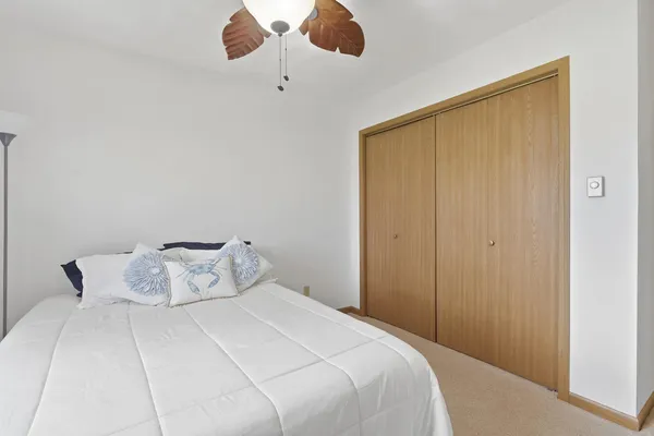 a bedroom with a bed and ceiling fan