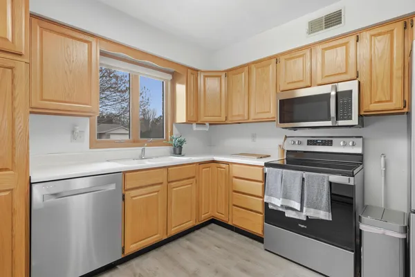 a kitchen with cabinets stainless steel appliances and a window