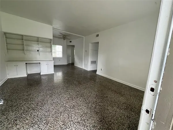 an empty room with a fireplace and cabinet