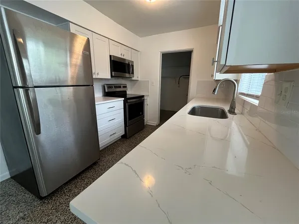 a kitchen with a refrigerator and a sink