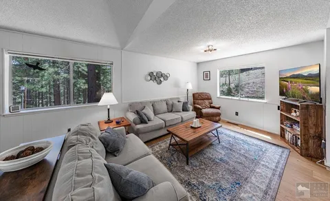 a living room with furniture a flat screen tv and a large window