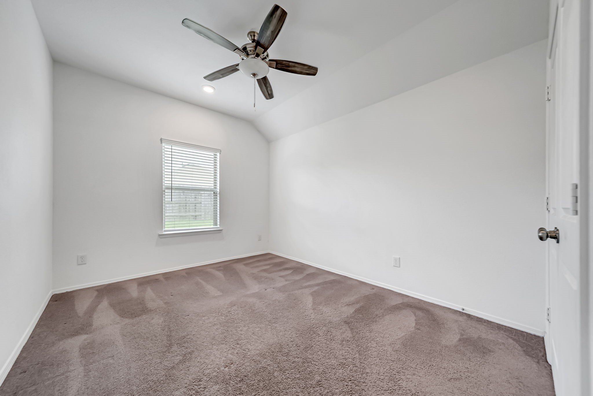 2847 Mistygate Court Conroe, TX 77301 - Photo 11 of 27 This room features clean white walls, a ceiling fan, and a single window providing natural light. The carpeted floor adds warmth, making it a cozy space.