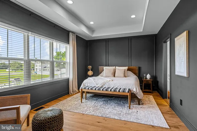a bed sitting in a spacious bedroom next to a window