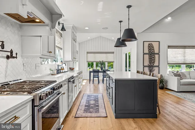 a kitchen with stainless steel appliances granite countertop a stove and a wooden floors