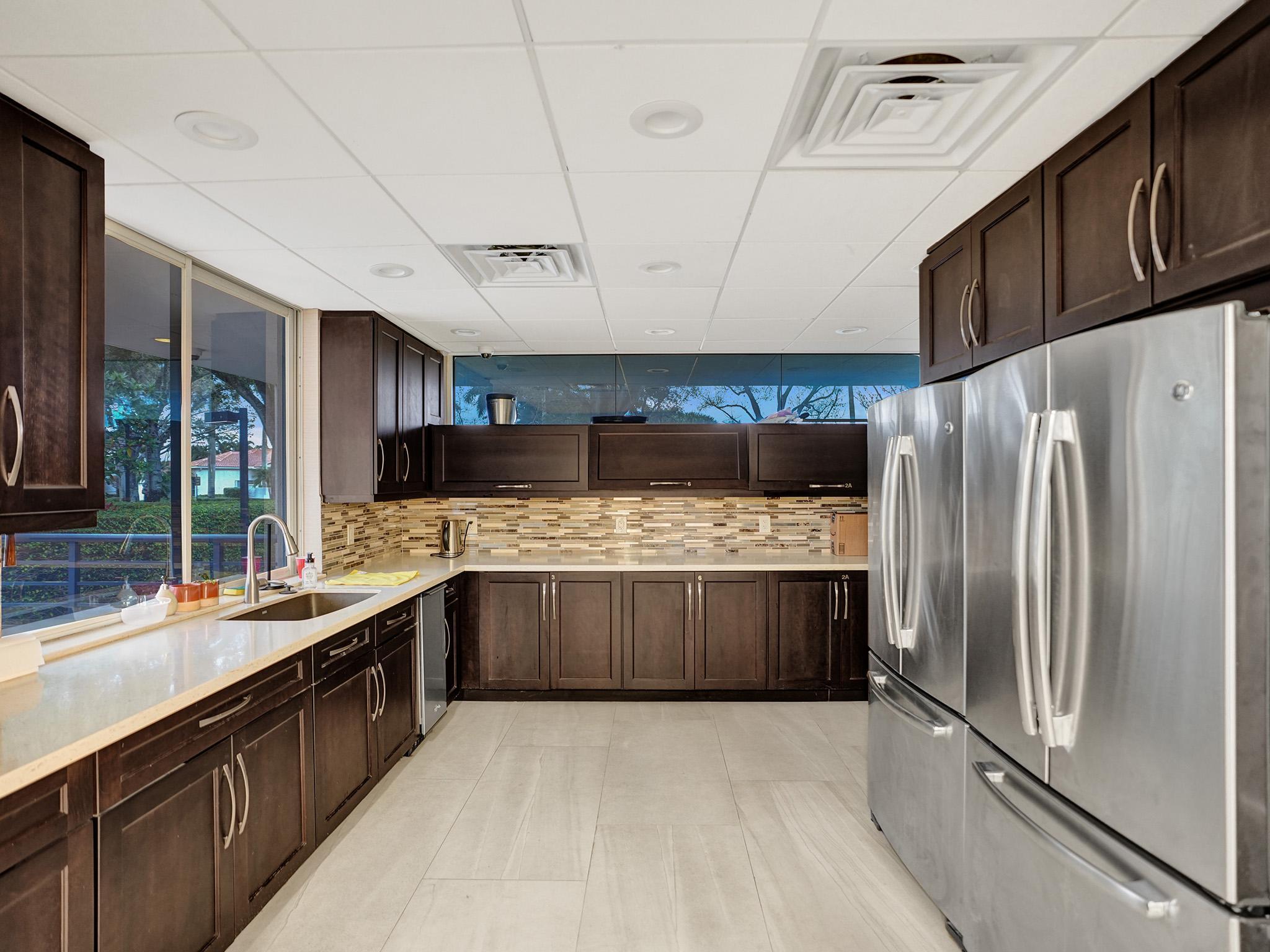 17288 Hampton Boulevard Boca Raton, FL 33496 - Photo 30 of 36 a large kitchen with a large counter top stainless steel appliances and cabinets