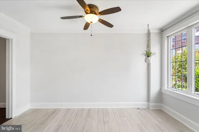 an empty room with windows and fan