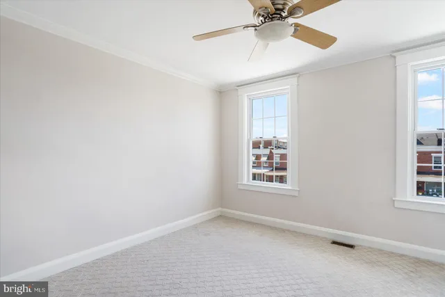 an empty room with a window and a fan
