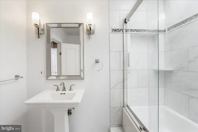 a bathroom with a sink a mirror a vanity and shower