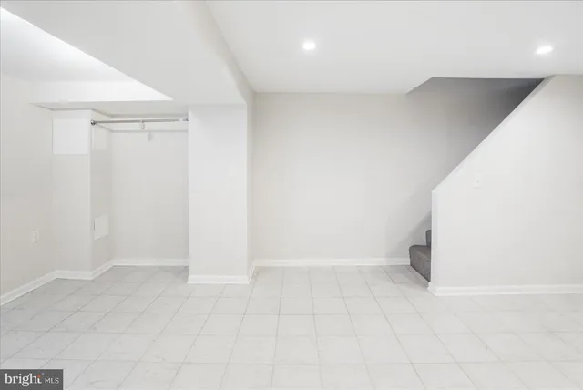 an empty room with white walls and tiles
