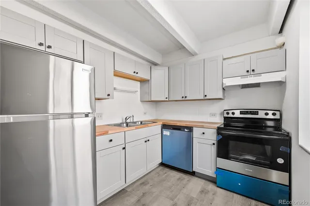 a kitchen with a refrigerator sink and cabinets