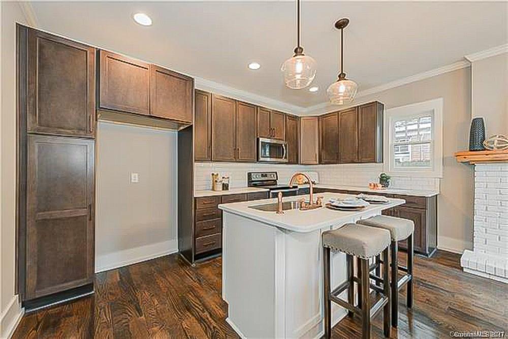 2116 Rozzelles Ferry Road Charlotte, NC 28208 - Photo 15 of 24 a kitchen with a refrigerator a sink and cabinets