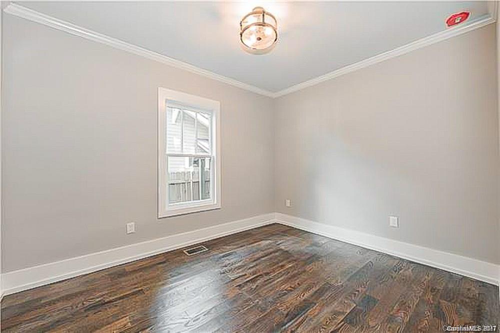 2116 Rozzelles Ferry Road Charlotte, NC 28208 - Photo 16 of 24 an empty room with wooden floor and window