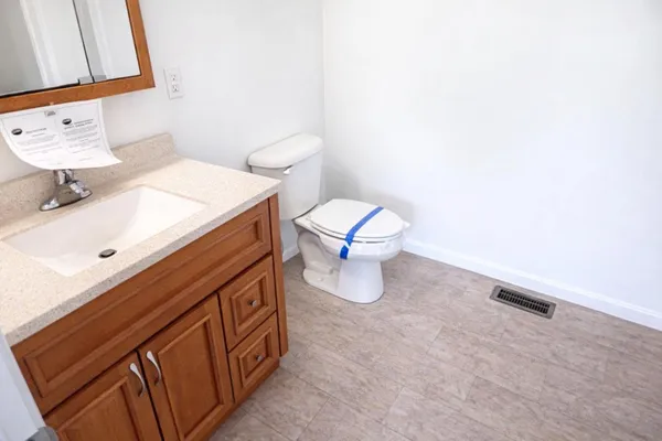 a bathroom with a sink a toilet and a mirror