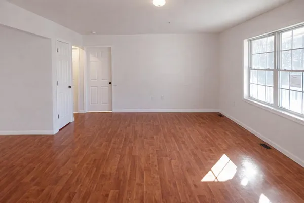 wooden floor in an empty room with a window