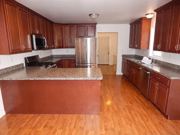 a large kitchen with wooden floors and wooden cabinets