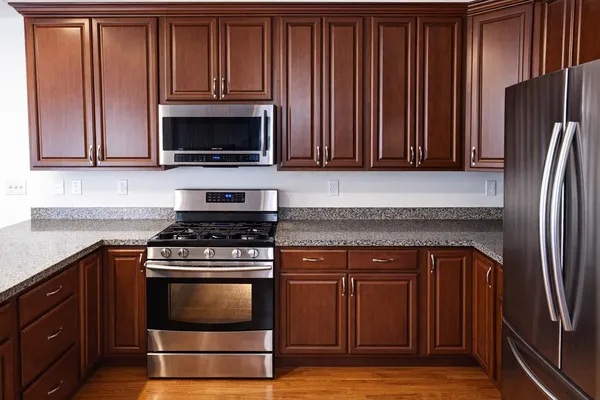 a kitchen with granite countertop wooden cabinets and a stove top oven