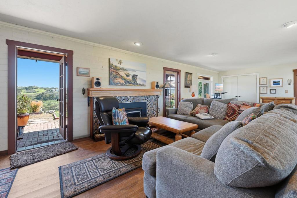 1355 Rainbow Ridge Lane Encinitas, CA 92024 - Photo 21 of 45 a living room with furniture large window and a fireplace
