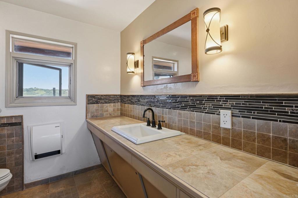 1355 Rainbow Ridge Lane Encinitas, CA 92024 - Photo 26 of 45 a bathroom with a sink and a mirror