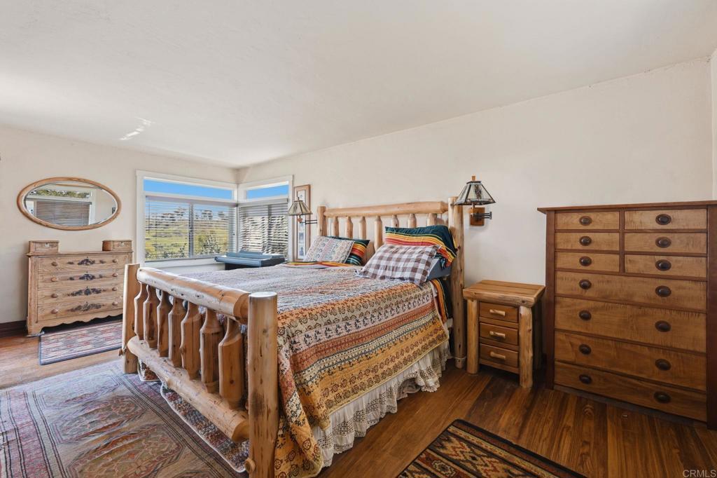1355 Rainbow Ridge Lane Encinitas, CA 92024 - Photo 27 of 45 a bedroom with a bed next to a window and cabinets