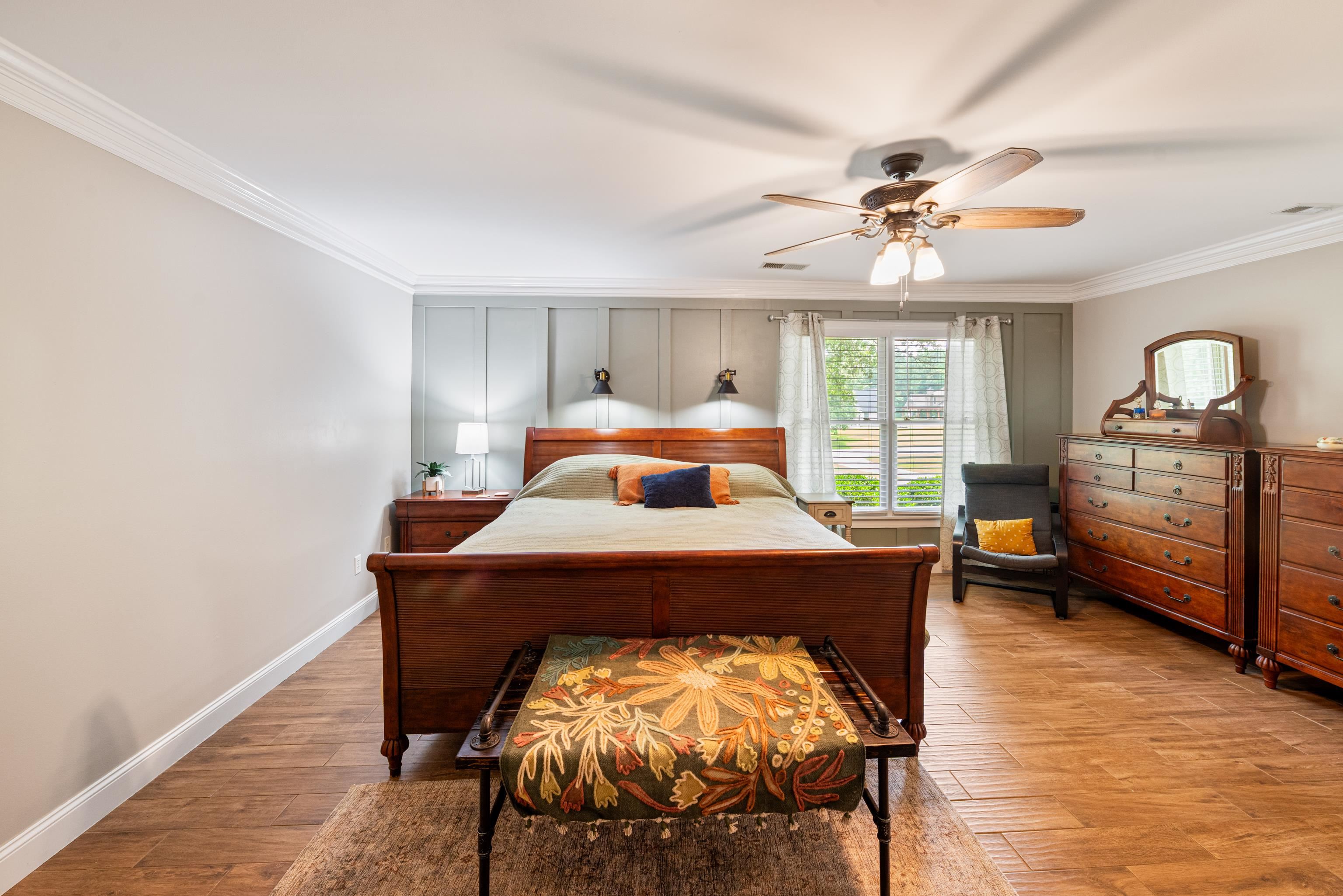 Bedroom with ornamental molding, wood finished floors, baseboards, and ceiling fan