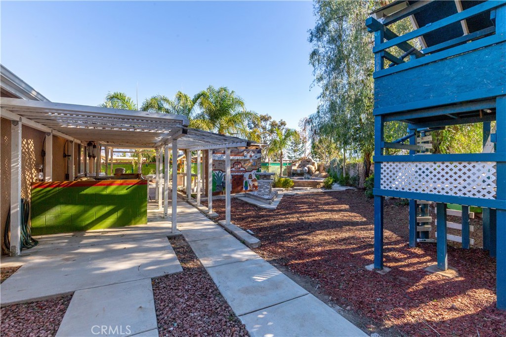 1457 Faircliff Street Beaumont, CA 92223 - Photo 30 of 37 a view of a patio with a table and chairs under an umbrella with a fire pit