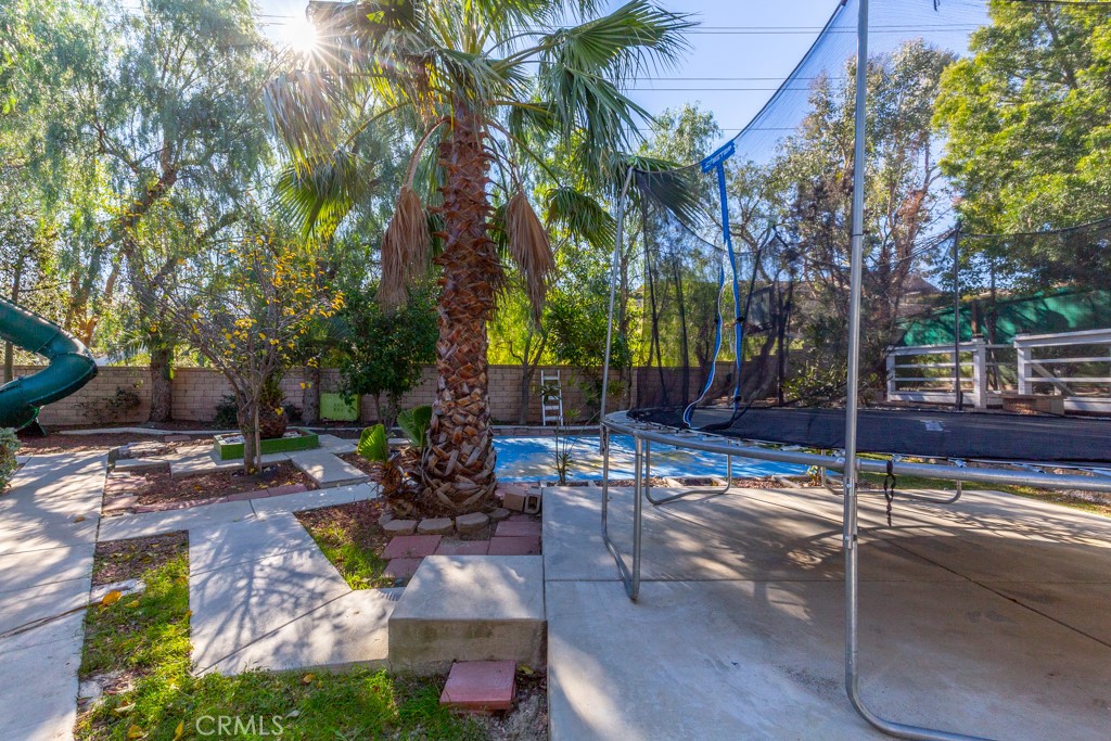 1457 Faircliff Street Beaumont, CA 92223 - Photo 33 of 37 a view of a patio with table and chairs potted plants and large tree