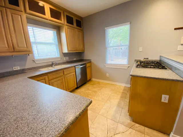a kitchen with sink a window and cabinets