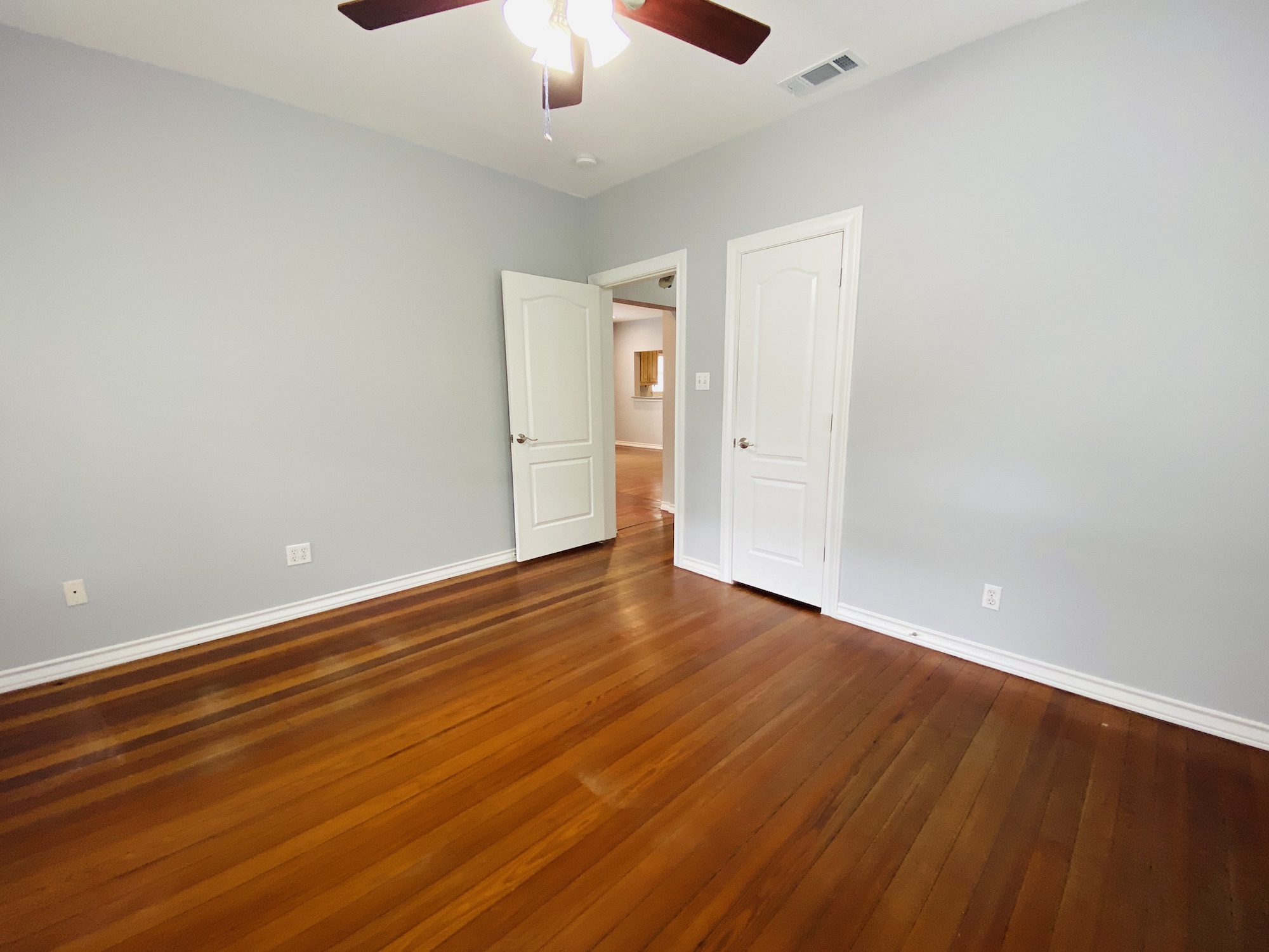 404 East 35th Street, Unit A Austin, TX 78705 - Photo 19 of 36 an empty room with wooden floor chandelier fan and windows