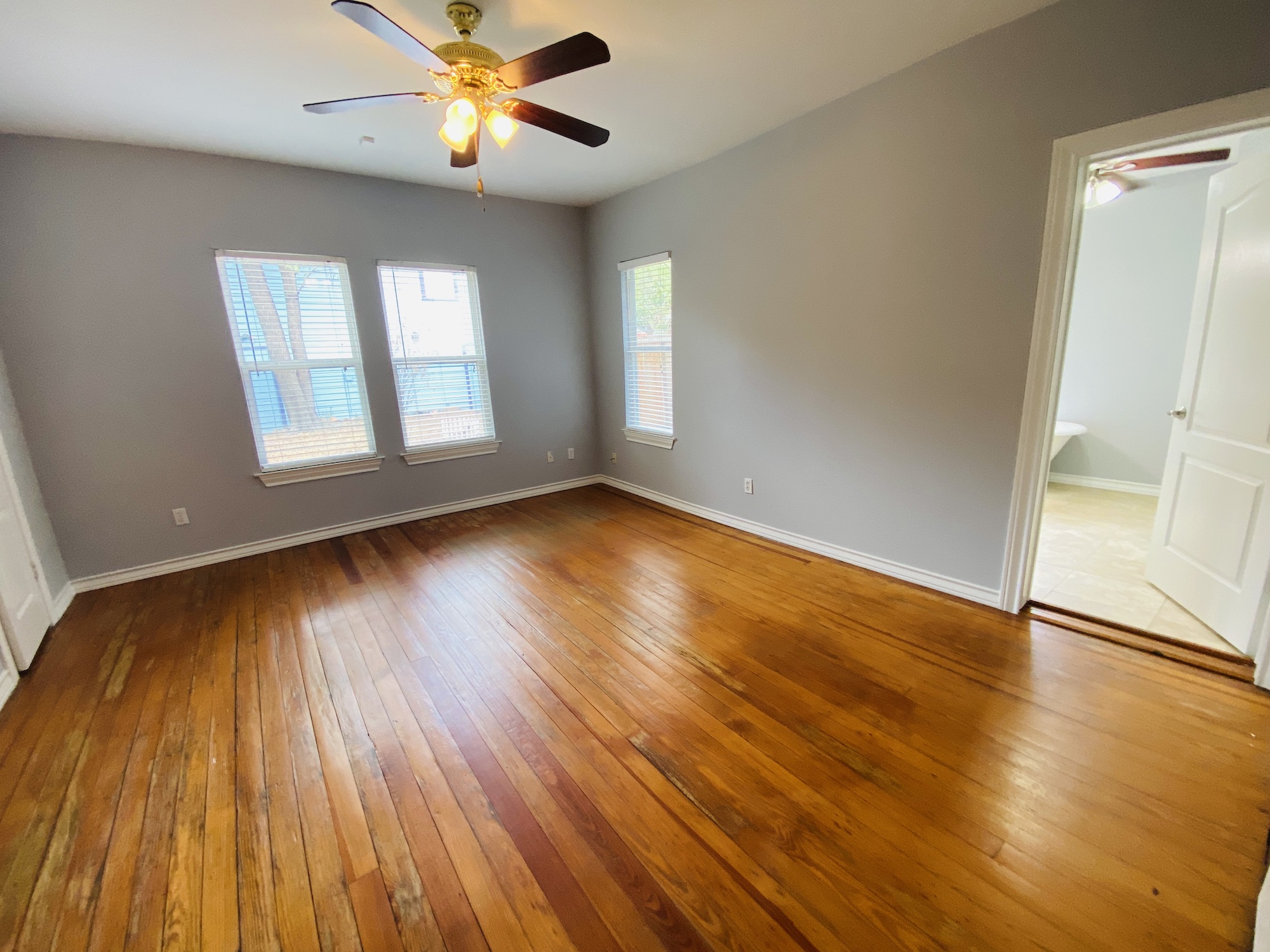 404 East 35th Street, Unit A Austin, TX 78705 - Photo 26 of 36 an empty room with wooden floor chandelier fan and windows