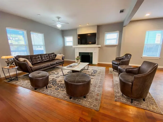a living room with furniture a fireplace and a flat screen tv