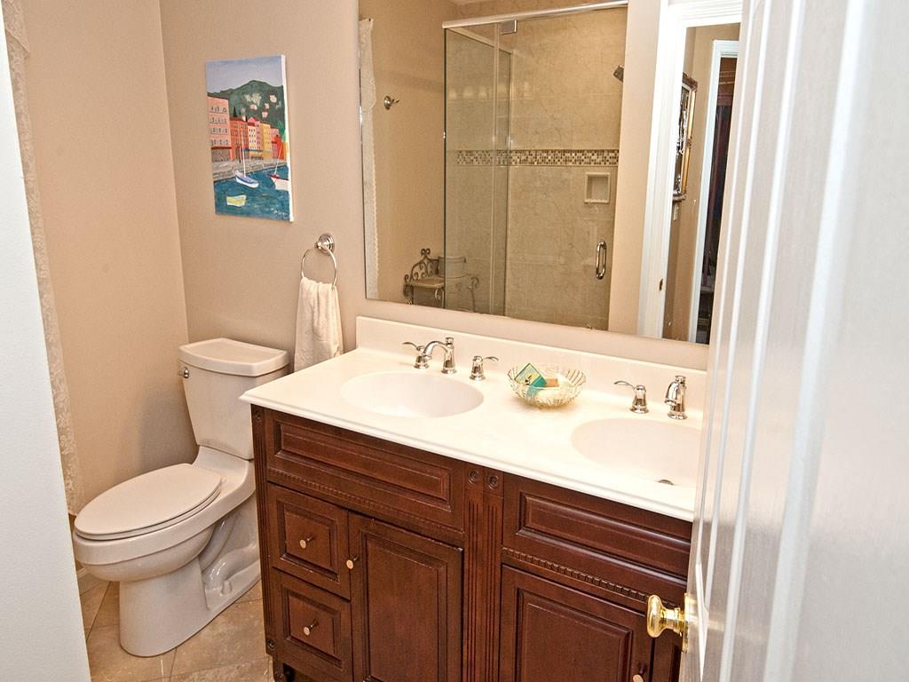 208 Ruth Way McDonald, PA 15057 - Photo 11 of 23 Updated master bath features tile floor, stately wood vanity with double bowl, and a large tile shower with glass enclosure.
