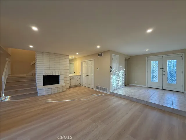 a view of an empty room with a fireplace and a window