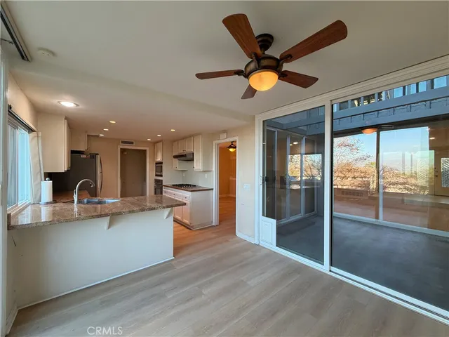 a view of a kitchen with kitchen island a large counter space a sink and stainless steel appliances