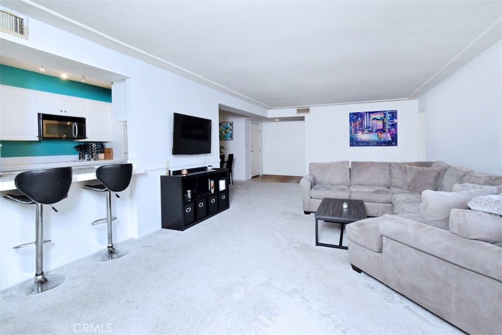 5050 Coldwater Canyon Avenue, Unit 306 Sherman Oaks, CA 91423 - Photo 11 of 24 a living room with furniture and a flat screen tv