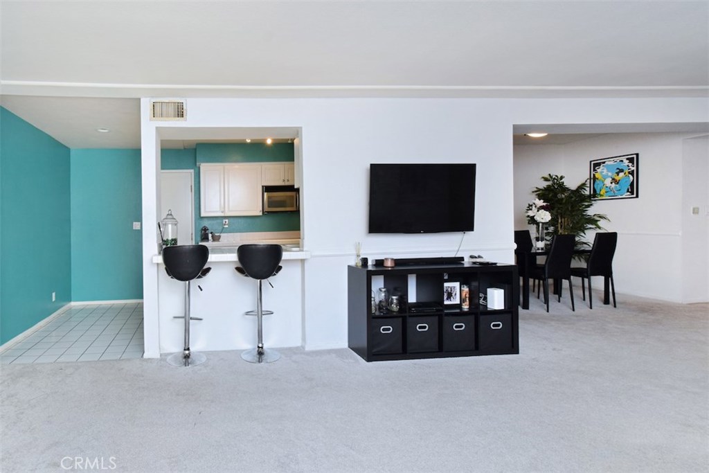 5050 Coldwater Canyon Avenue, Unit 306 Sherman Oaks, CA 91423 - Photo 12 of 24 a living room with furniture and a flat screen tv