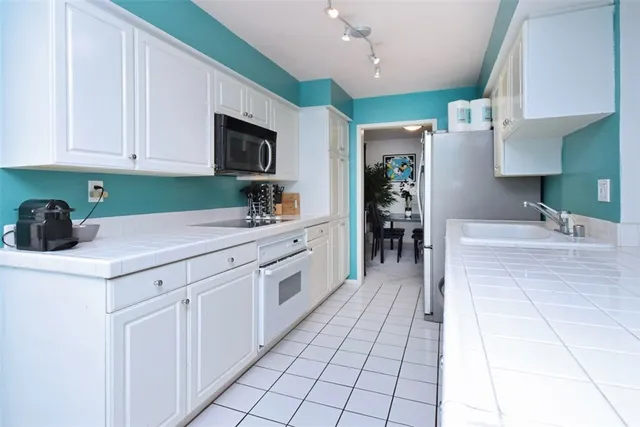a kitchen with stainless steel appliances a sink stove and cabinets