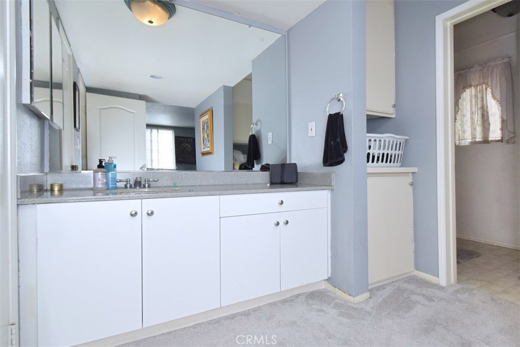 5050 Coldwater Canyon Avenue, Unit 306 Sherman Oaks, CA 91423 - Photo 22 of 24 a bathroom with a double vanity sink and a mirror