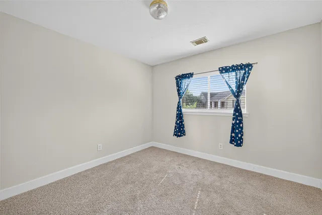 an empty room with windows and flowerpot