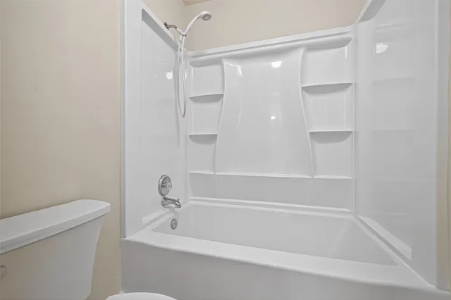 a bathroom with a tub and a toilet