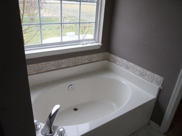 958 Rocky Valley Road Lebanon, TN 37090 - Photo 7 of 20 a bath tub sitting in a bathroom next to a window