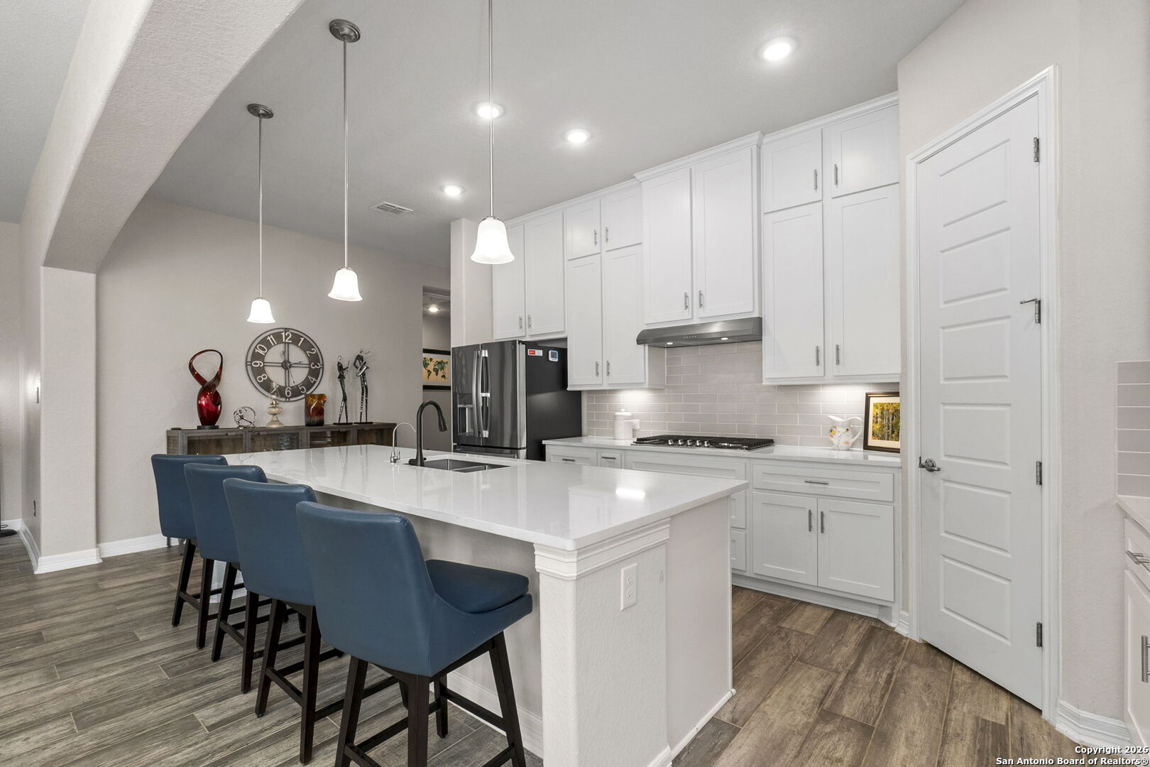 705 Tree Top Pass New Braunfels, TX 78130 - Photo 6 of 49 a kitchen with kitchen island a stove a table and chairs in it