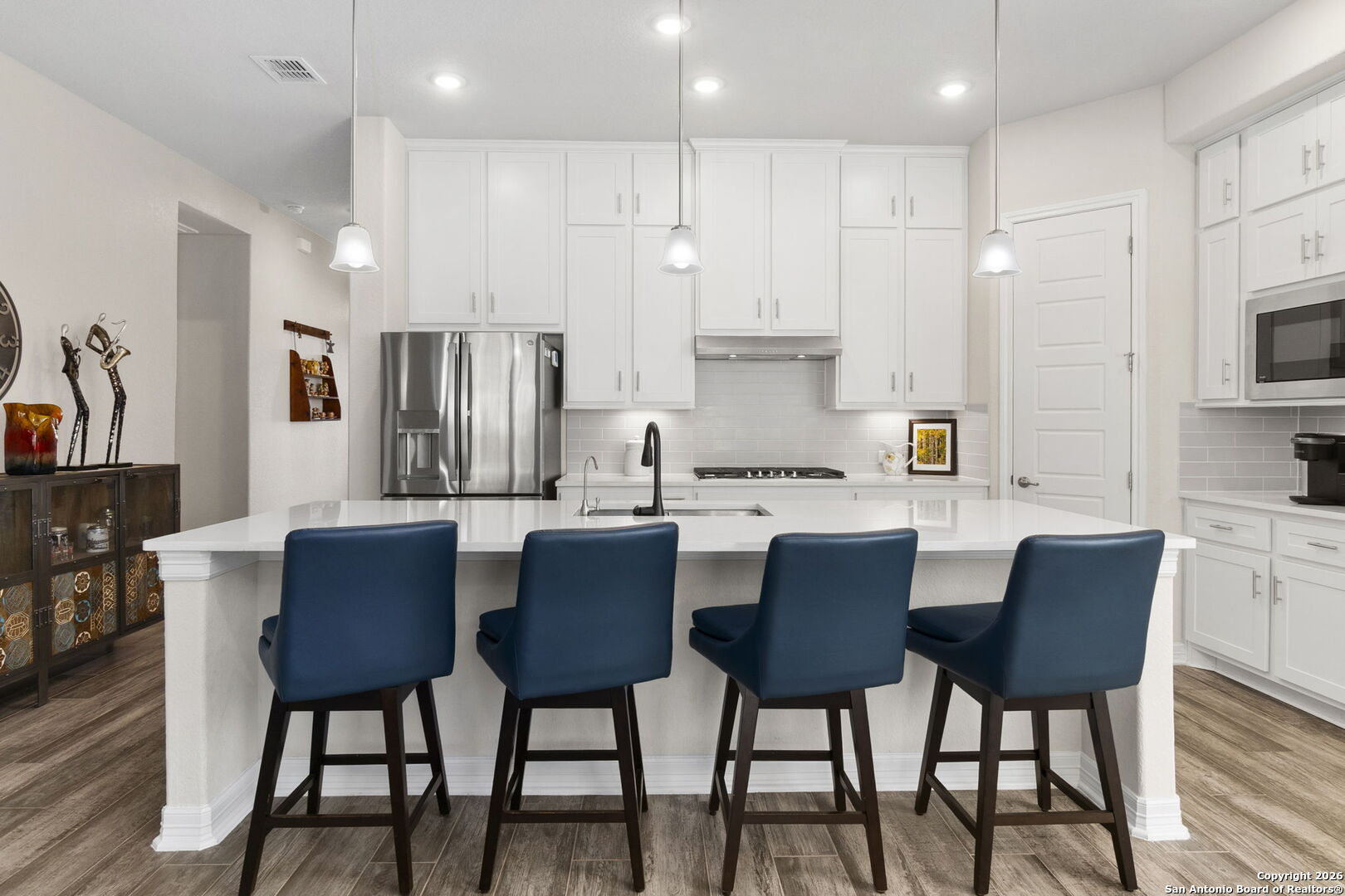 705 Tree Top Pass New Braunfels, TX 78130 - Photo 7 of 49 a kitchen with stainless steel appliances granite countertop a kitchen island a table and chairs