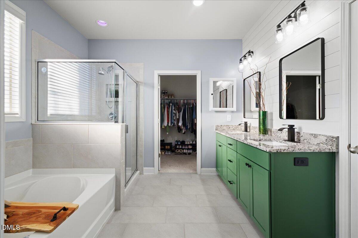 7804 Charters End Street Willow Spring, NC 27592 - Photo 20 of 43 a bathroom with a tub sink and mirror