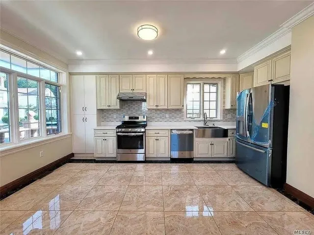 a kitchen with stainless steel appliances a refrigerator sink and cabinets