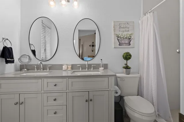 a bathroom with a toilet a sink and a mirror