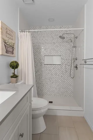 a bathroom with a shower a toilet and a sink