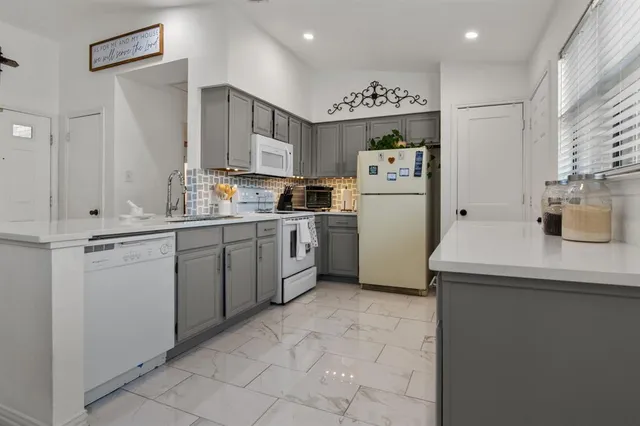 a kitchen with a sink a refrigerator and cabinets