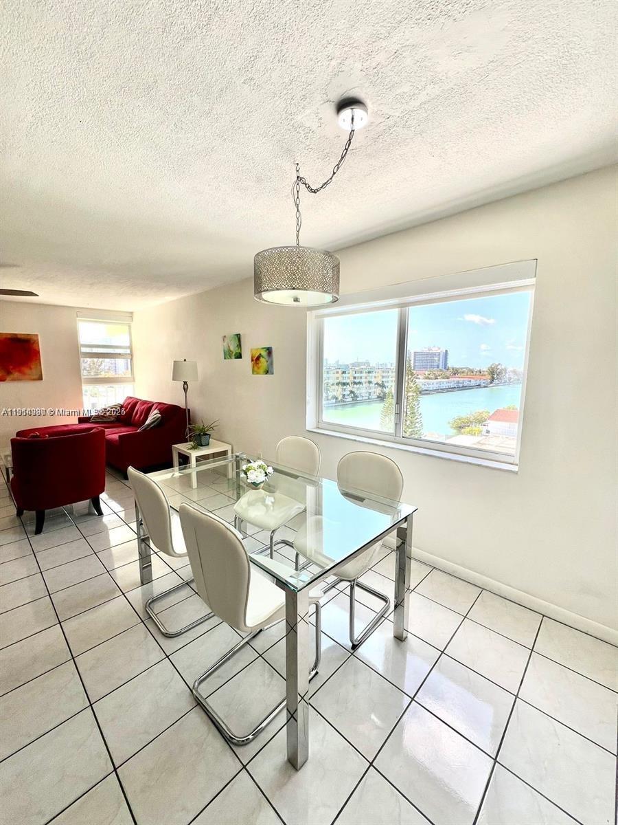 8001 Crespi Boulevard, Unit 6D Miami Beach, FL 33141 - Photo 12 of 29 a living room with furniture a flat screen tv and a window