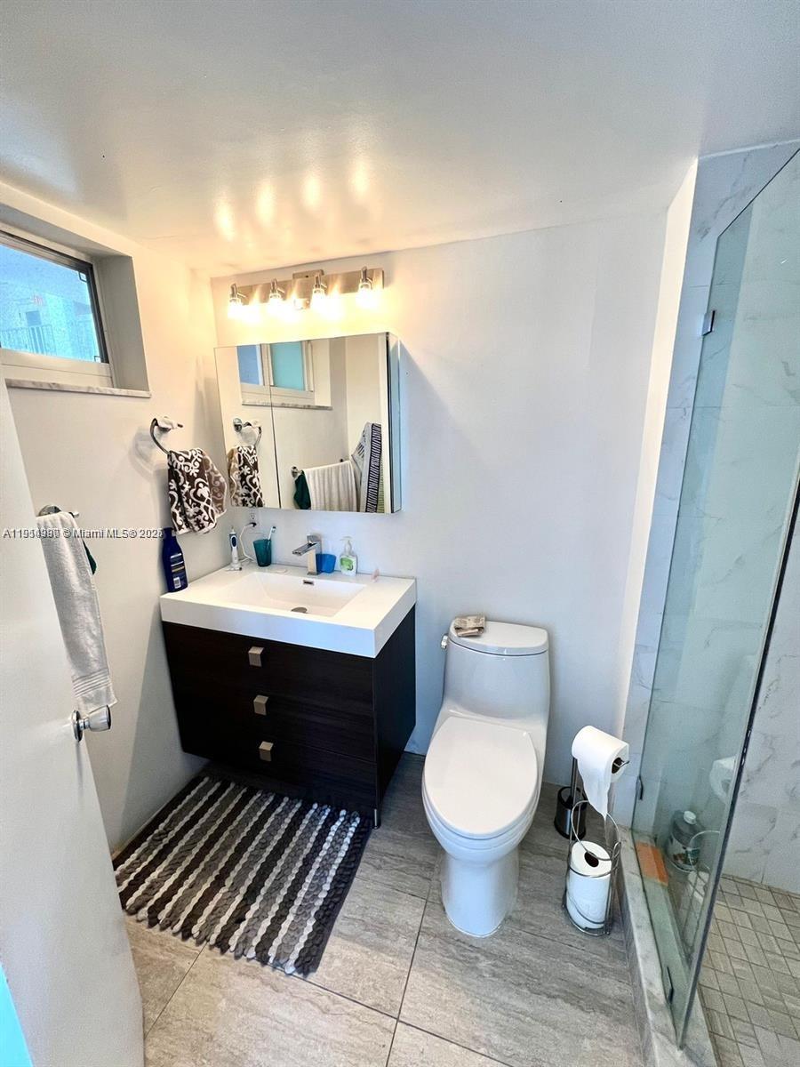 8001 Crespi Boulevard, Unit 6D Miami Beach, FL 33141 - Photo 17 of 29 a bathroom with a sink toilet and mirror
