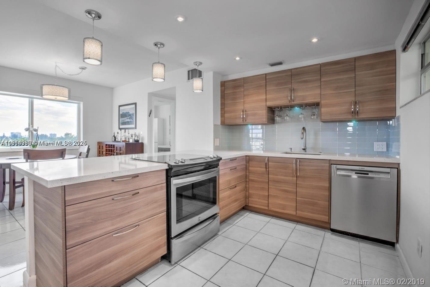 8001 Crespi Boulevard, Unit 6D Miami Beach, FL 33141 - Photo 4 of 29 a kitchen with granite countertop cabinets stainless steel appliances and a sink